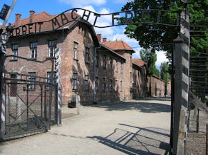 a brick building with Auschwitz concentration camp in the background
