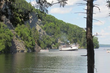 a small boat in a body of water surrounded by trees