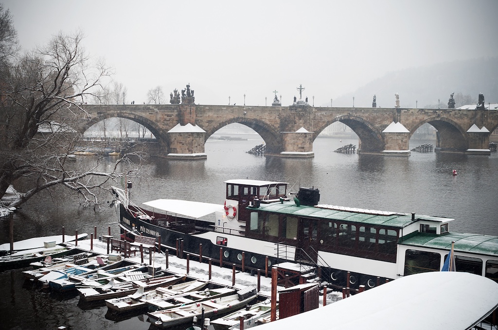 a view of the Vltava River in Prague and the Charles Bridge in the winter