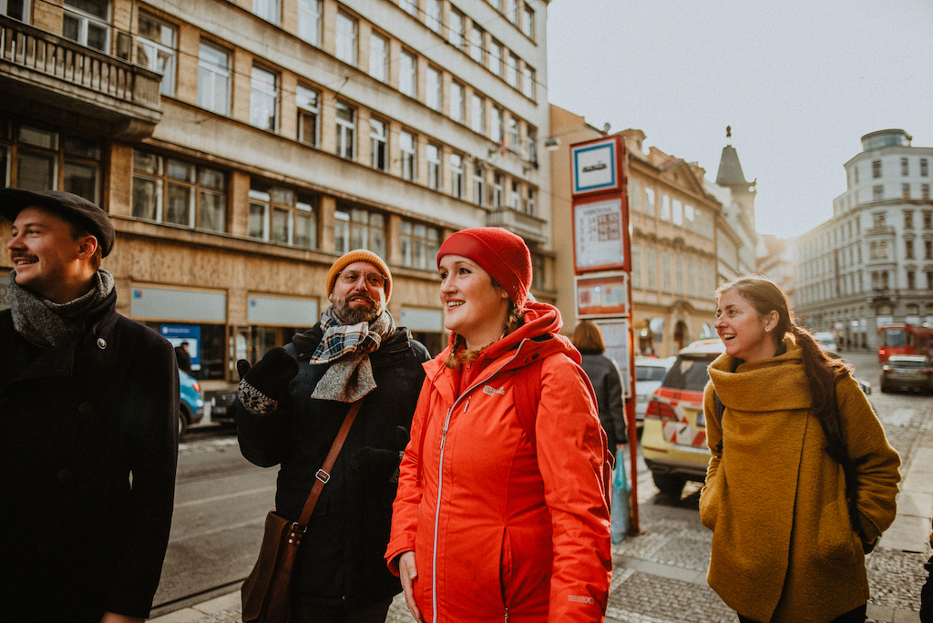 a tour guide leading a group of tourists on a Prague walking tour in the winter