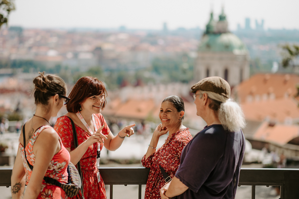 a group of tourists and a tour guide enjoying the view of Prague from one of the royal gardens of Prague Castle