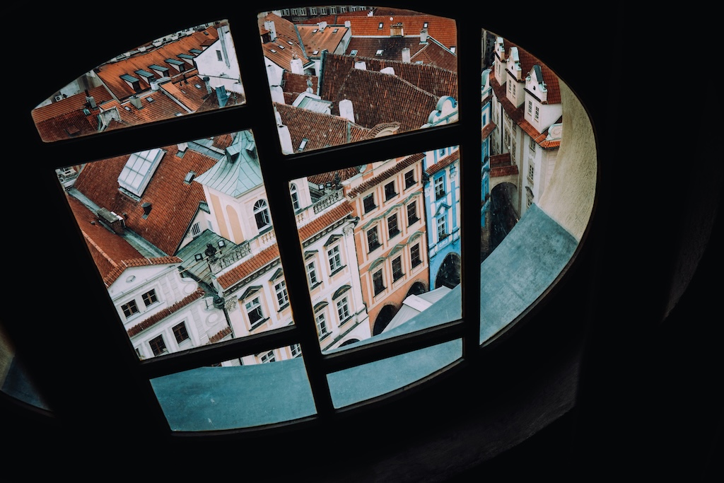 the rooftops in the Old Town of Prague seen from above through a window