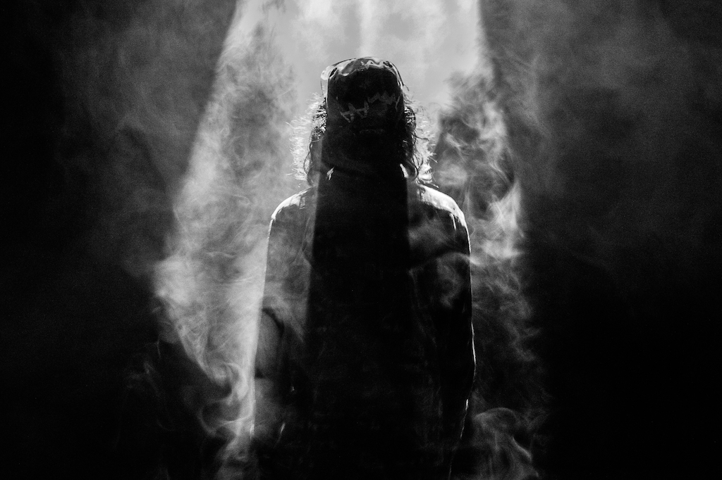a silhouette of a person standing in a shaded smoky area