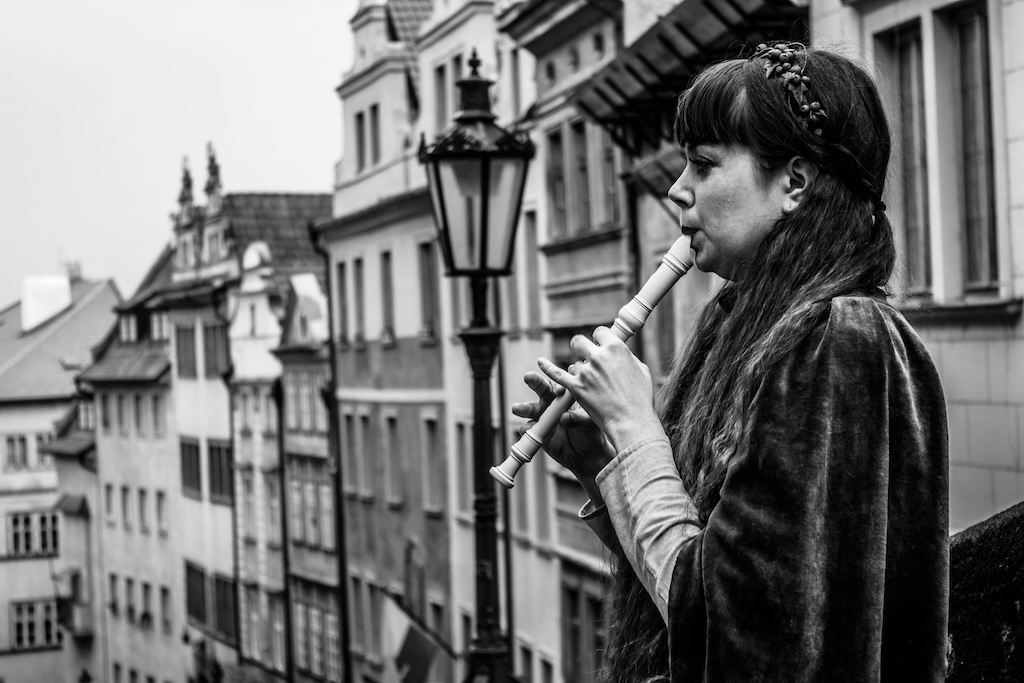 a woman playing a flute in Prague's Lesser Town