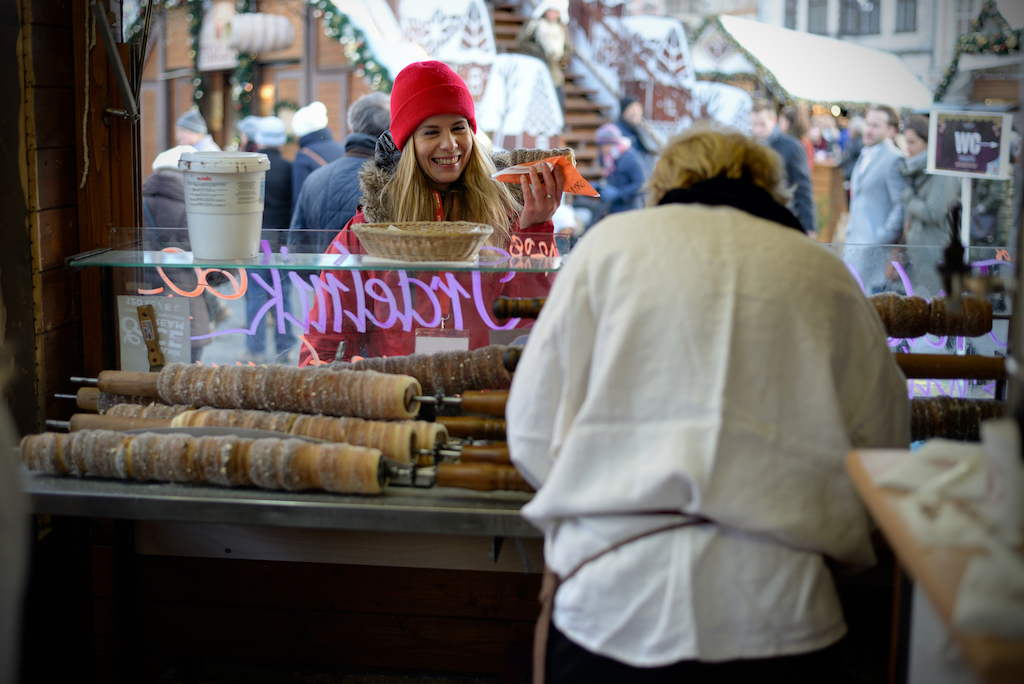 our Prague City guide Tereza holding a chimney cake or "trdelnik", a traditional Hungarian pastry that became a popular sweet dish in Prague