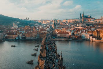 crowds of tourists on the iconic Charles Bridge in Prague, with the Lesser Town and Prague Castle in the background