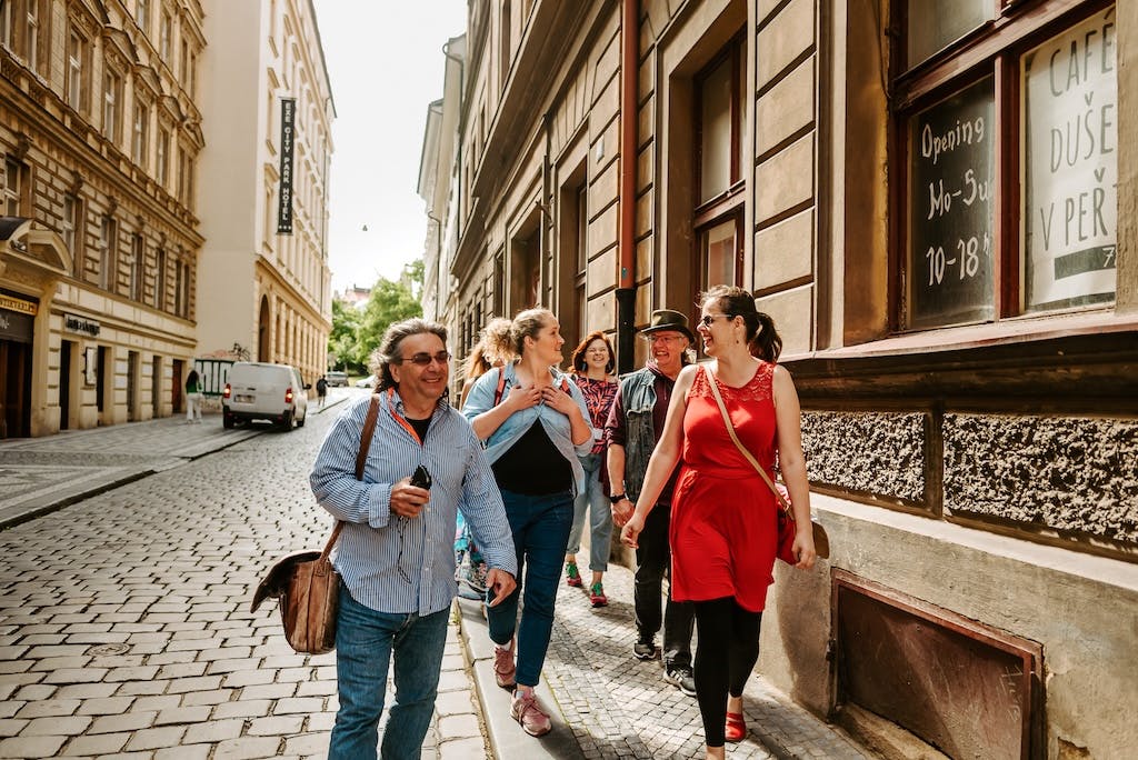 a tour guide leading a group of tourists through the streets of Prague on a private tour