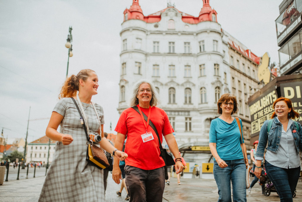 a tour guide leading a group of tourists around the Old Town of Prague on a walking tour