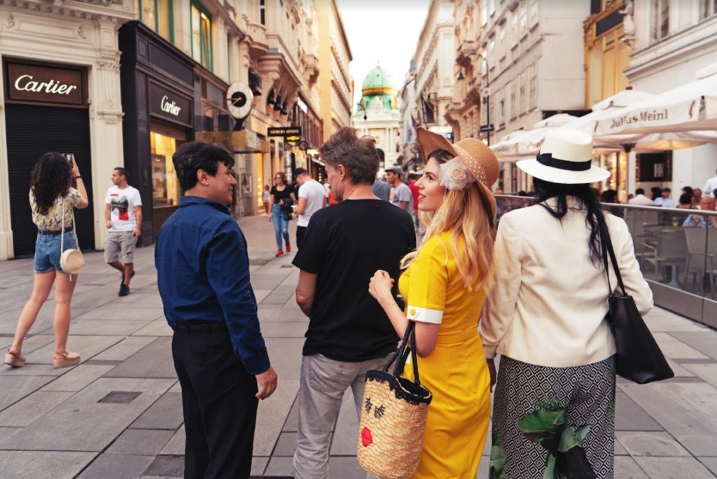 a group of tourists following a tour guide on a walking tour of Vienna