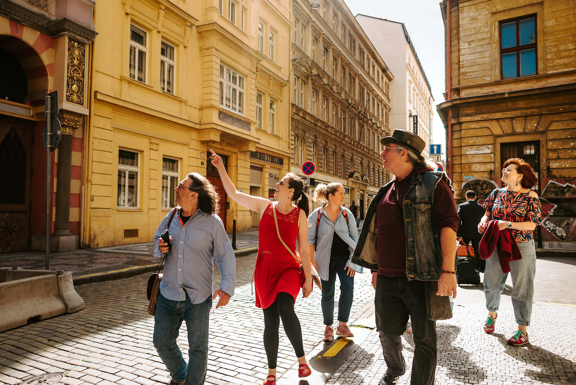 a group of tourists lead by a tourist guide through the streets of Prague