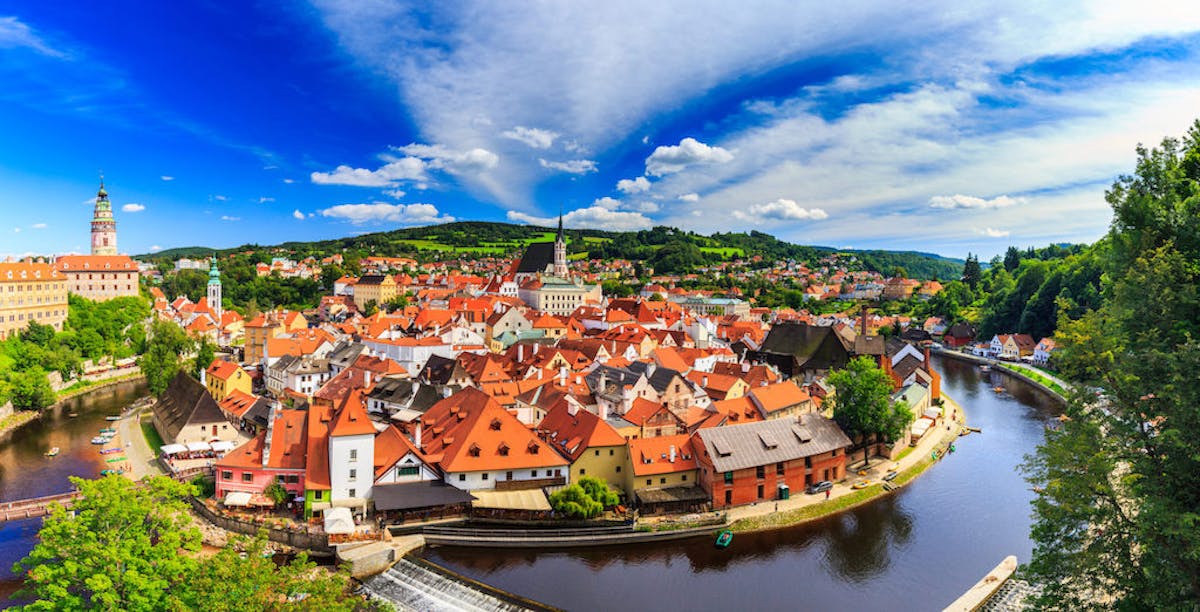a panoramic view of the historic center of Český Krumlov surrounded by a river bend