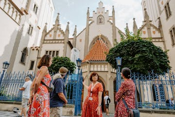a tour guide standing in front of a group of tourists and pointing at the Maisel Synagogue in the Jewish Quarter of Prague