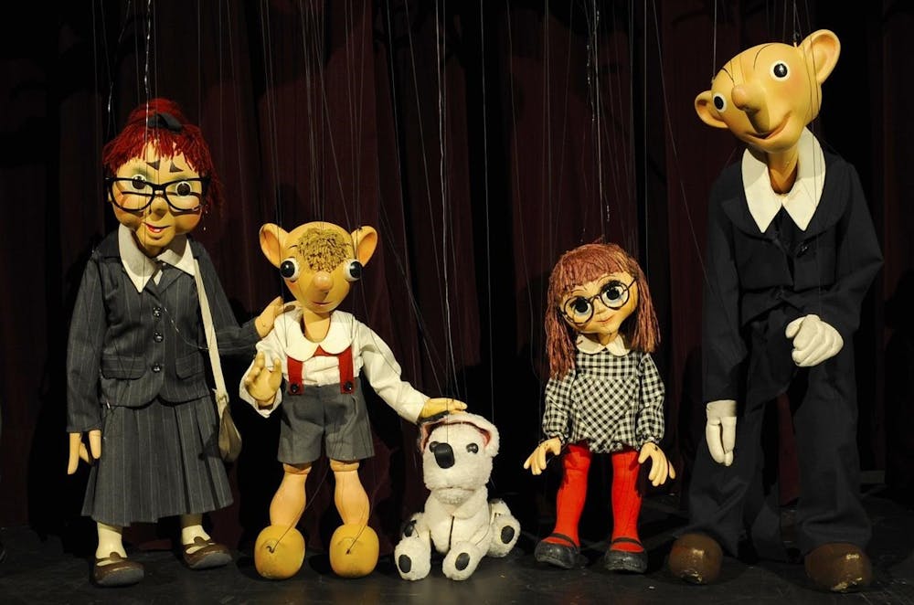 a group of teddy bears standing next to a toy doll