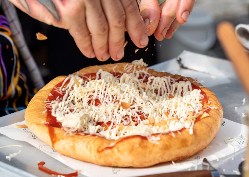 a close up of a person cutting a piece of pizza