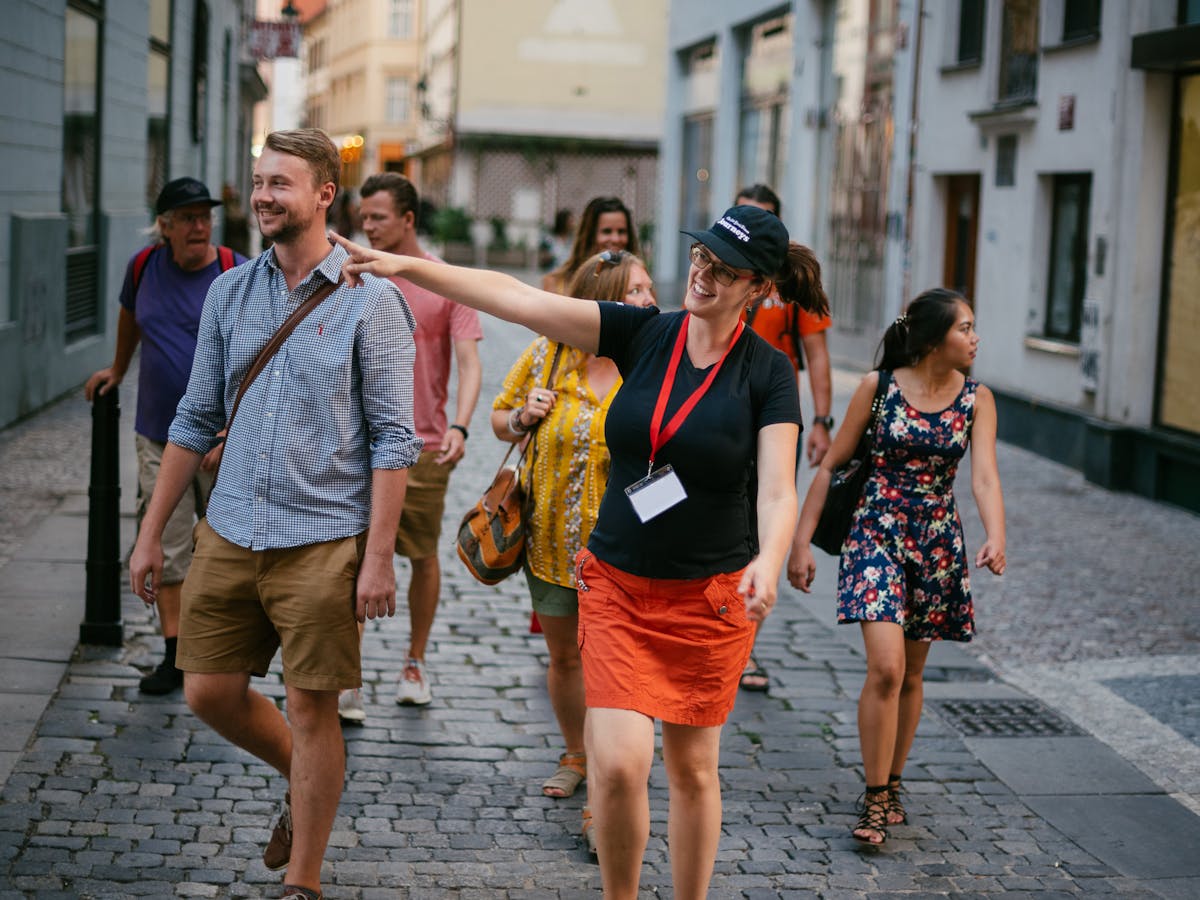 a tour guide leading a group of tourists through the streets of Prague's New Town