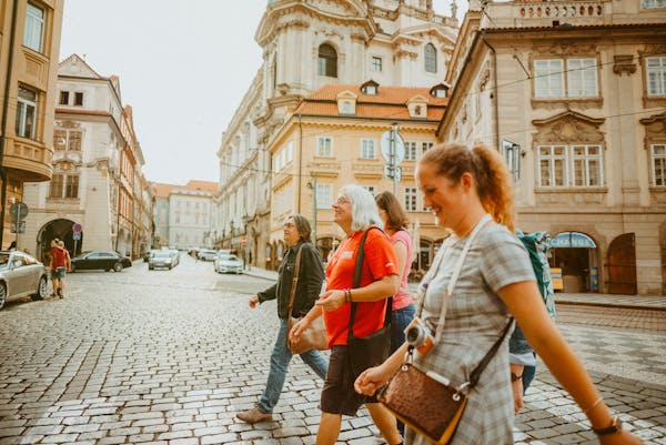 a group of tourists with a tour guide on a walking tour in Prague
