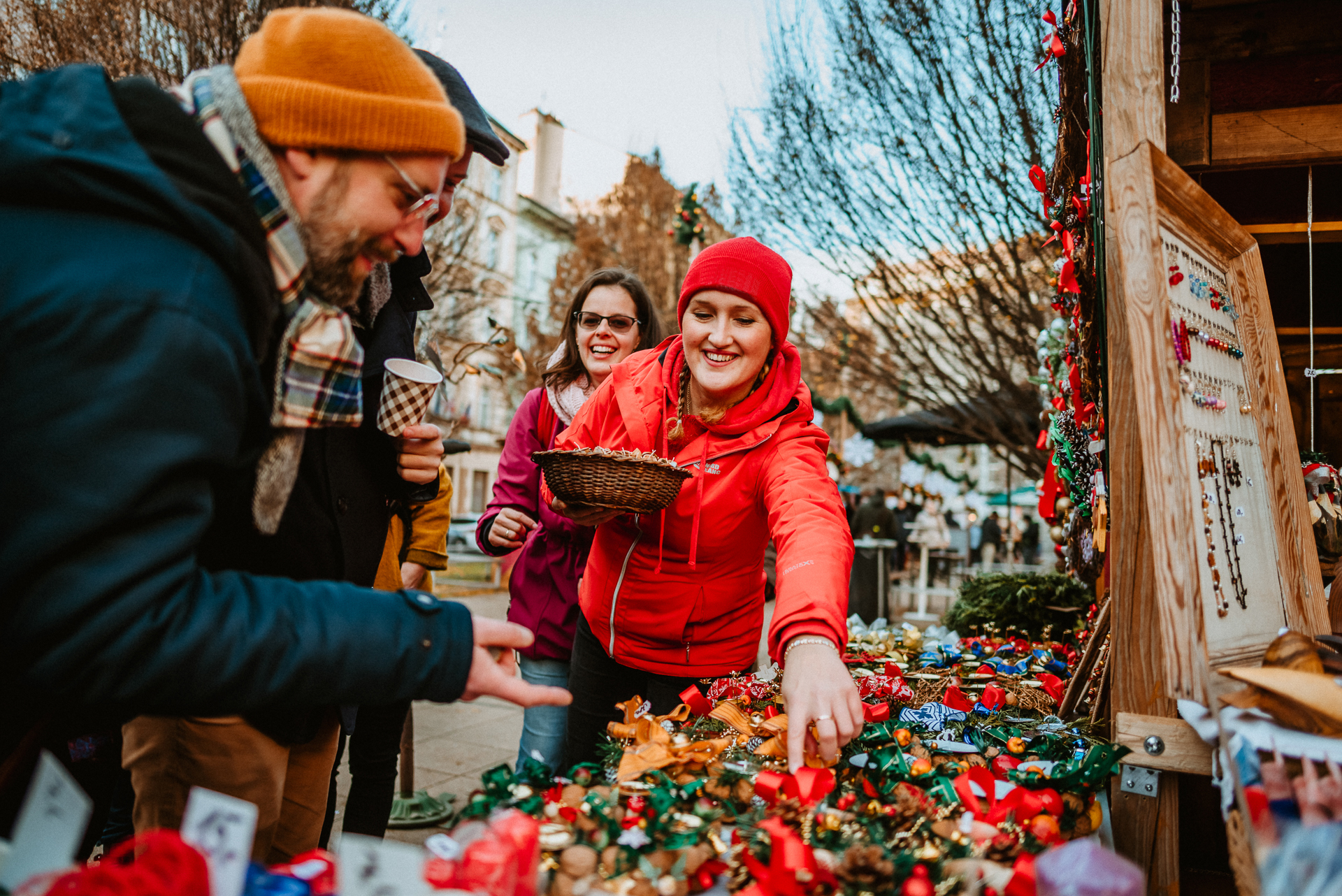 a tour guide browsing typical Czech Christmas souvenirs together with a group of tourists on a Prague Christmas Markets Tour