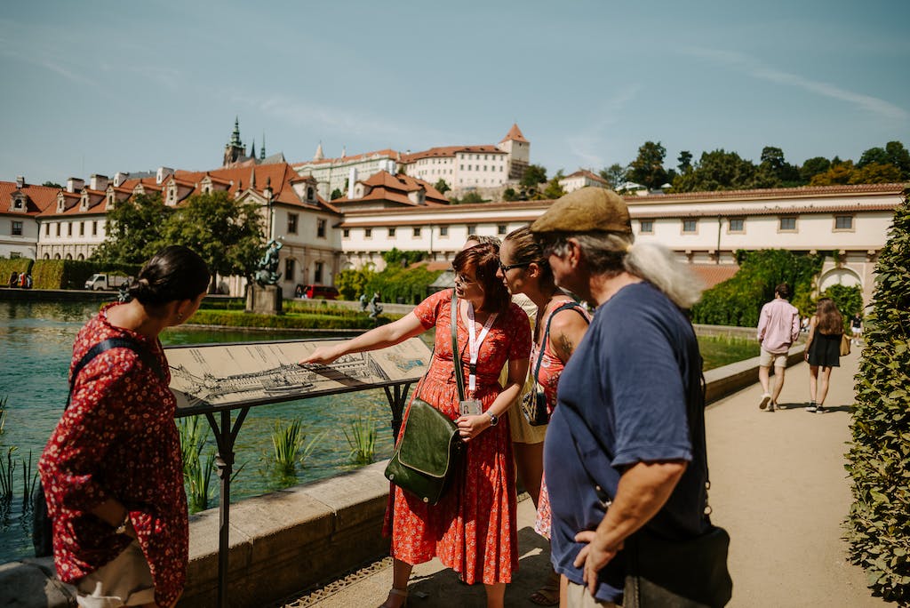 a tour guide showing a relief map of the Prague Castle complex to a group of tourists on a Prague Castle Tour