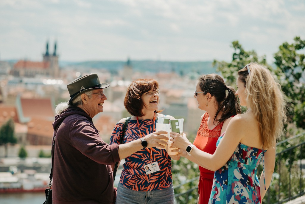 a group of tourists in Prague enjoying a glass of beer and beautiful views of Prague