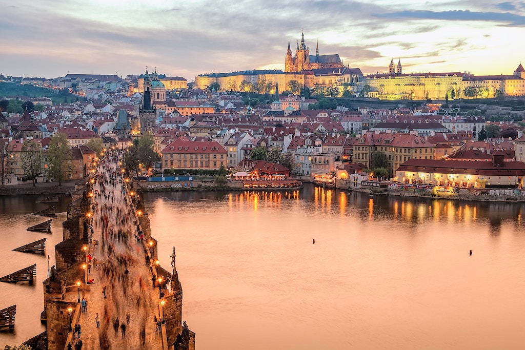the iconic Charles Bridge at the golden hour of sunset with an amazing view of Prague Castle in the beackground
