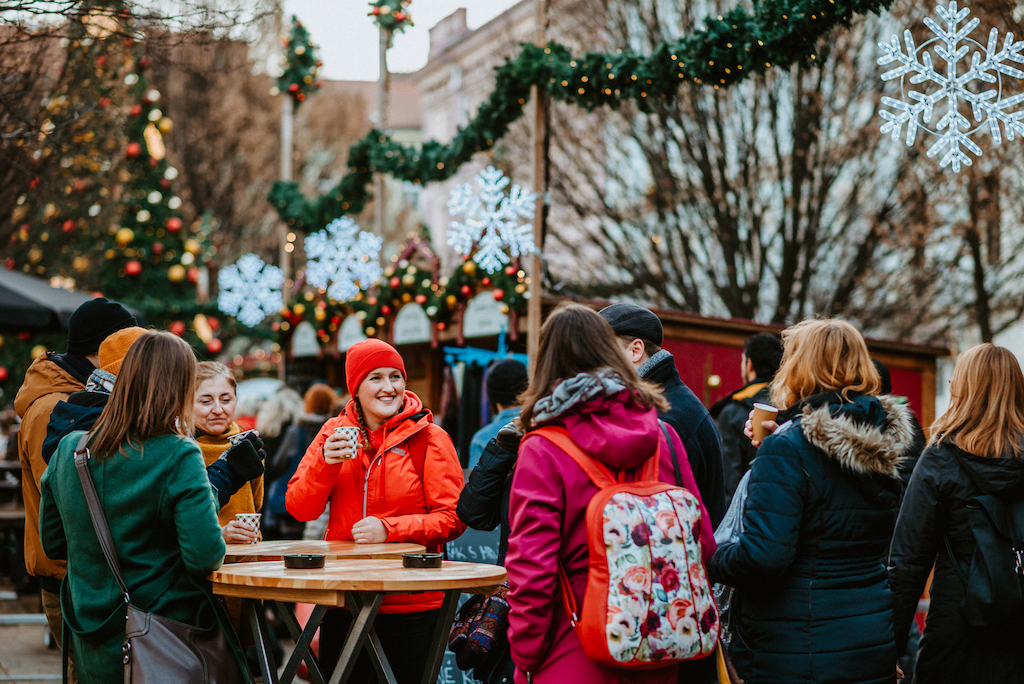 tourists enjoying a hot drink together with their tour guide on a Christmas Markets Tour in Prague