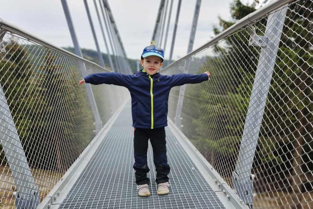 a happy boy walking on the Sky Bridge, the longest suspension bridge in the world located in eastern Czech Republic