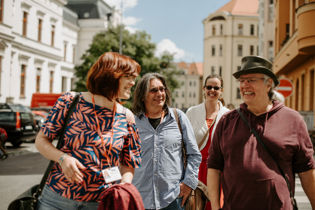 a group of tourists following a tour guide through the streets of Prague on a private tour