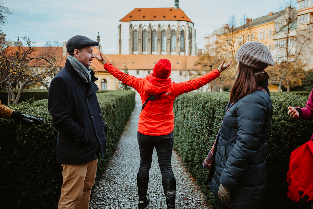 a tour guide with a group of tourists exploring the historic city center of Prague in the winter