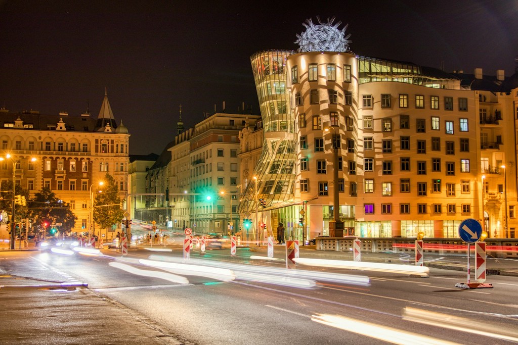 a close up of a busy city street in Prague's New Town at night
