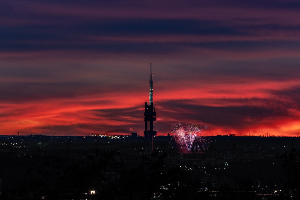 a panoramic view of Prague's Zizkov neighbourhood after sunset with a firework