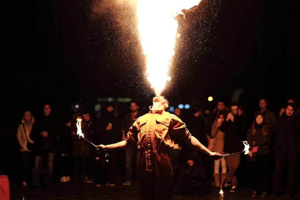 a person on the street performing a fire show as a part of the new year's eve celebrations