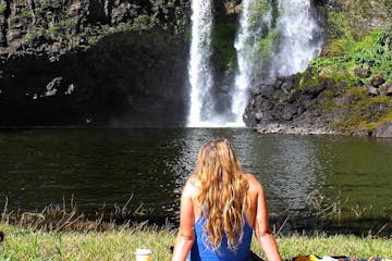 a person sitting next to a waterfall