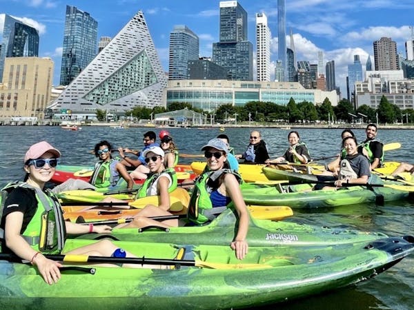 a group of people riding kayaks in NYC