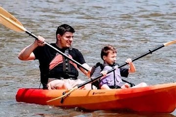 father and son riding a kayak together
