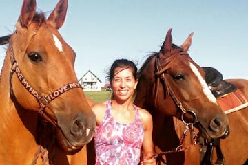 a group of people standing around a brown horse