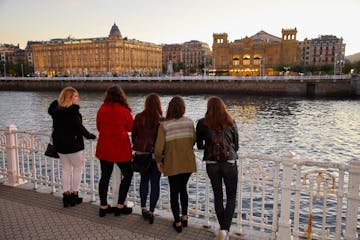 a group of people standing in front of a body of water