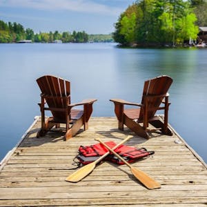 a row of wooden benches sitting next to a body of water