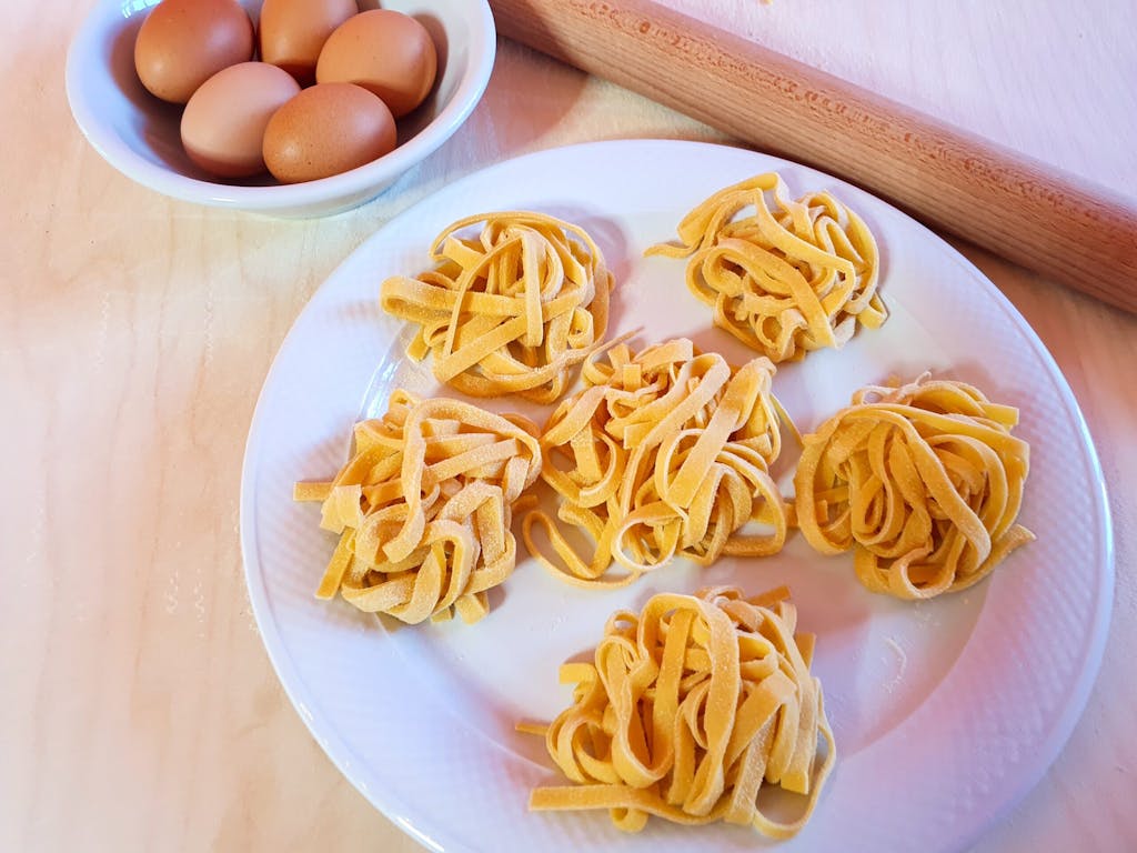 a plate of tagliatelle pasta and eggs on a table