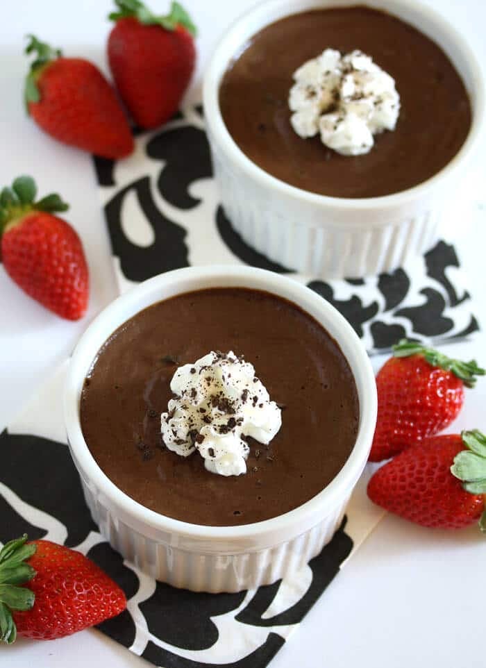 a cup of chocolate with whipped cream and strawberries