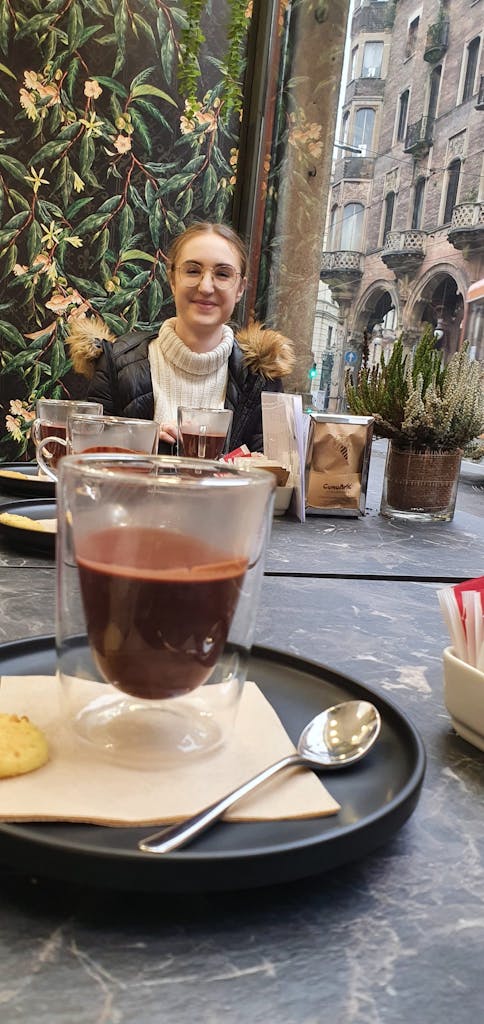 a person sitting at a table with a cup of chocolate