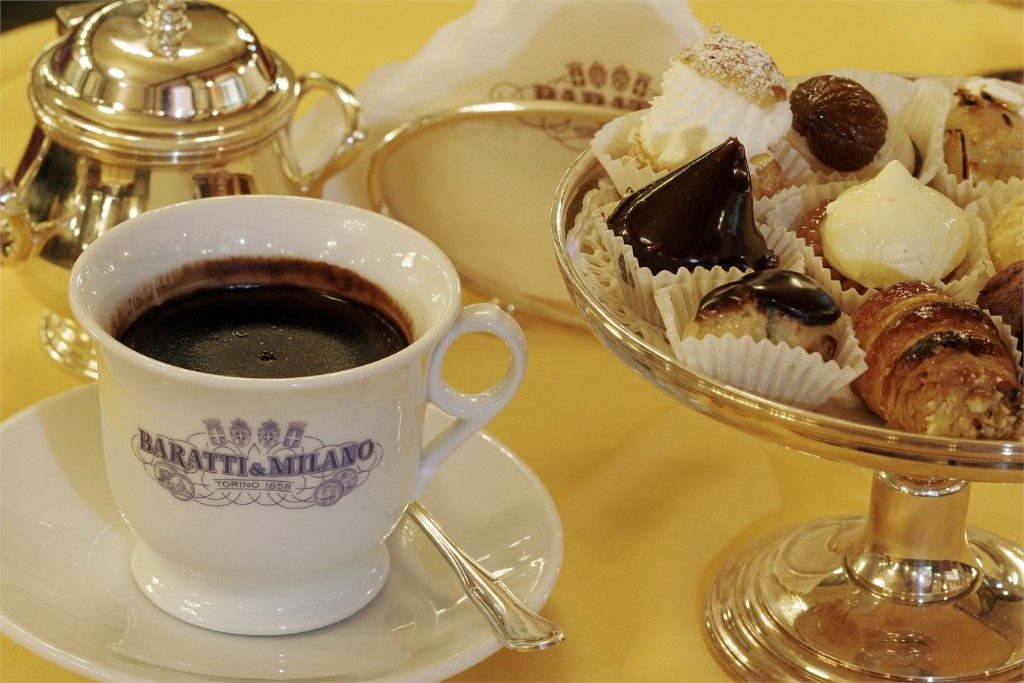 a cup of chocolate on a table with pastries