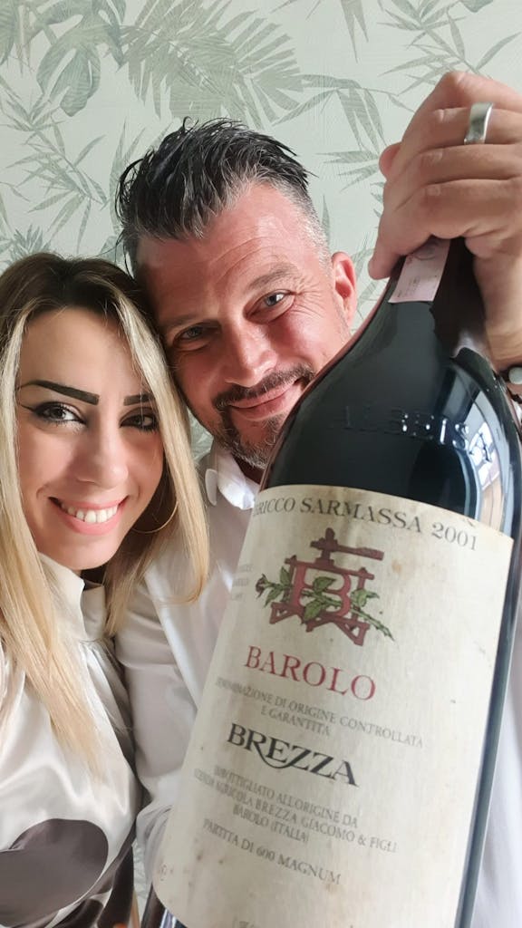 a woman holding a bottle of Barolo wine