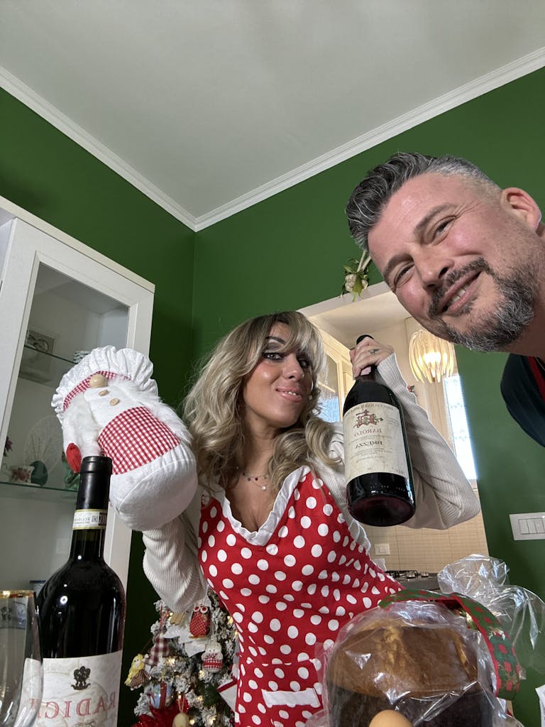 a man and a woman standing next to a bottle of wine