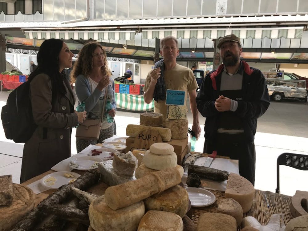 a group of people standing next to a cheese stand