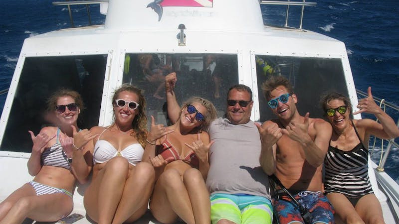 a group of people on a boat posing for the camera
