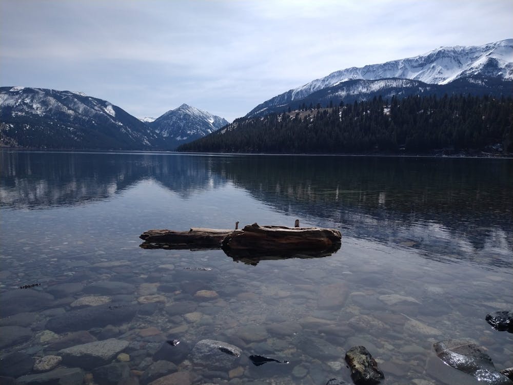 a small boat in a body of water with a mountain in the background
