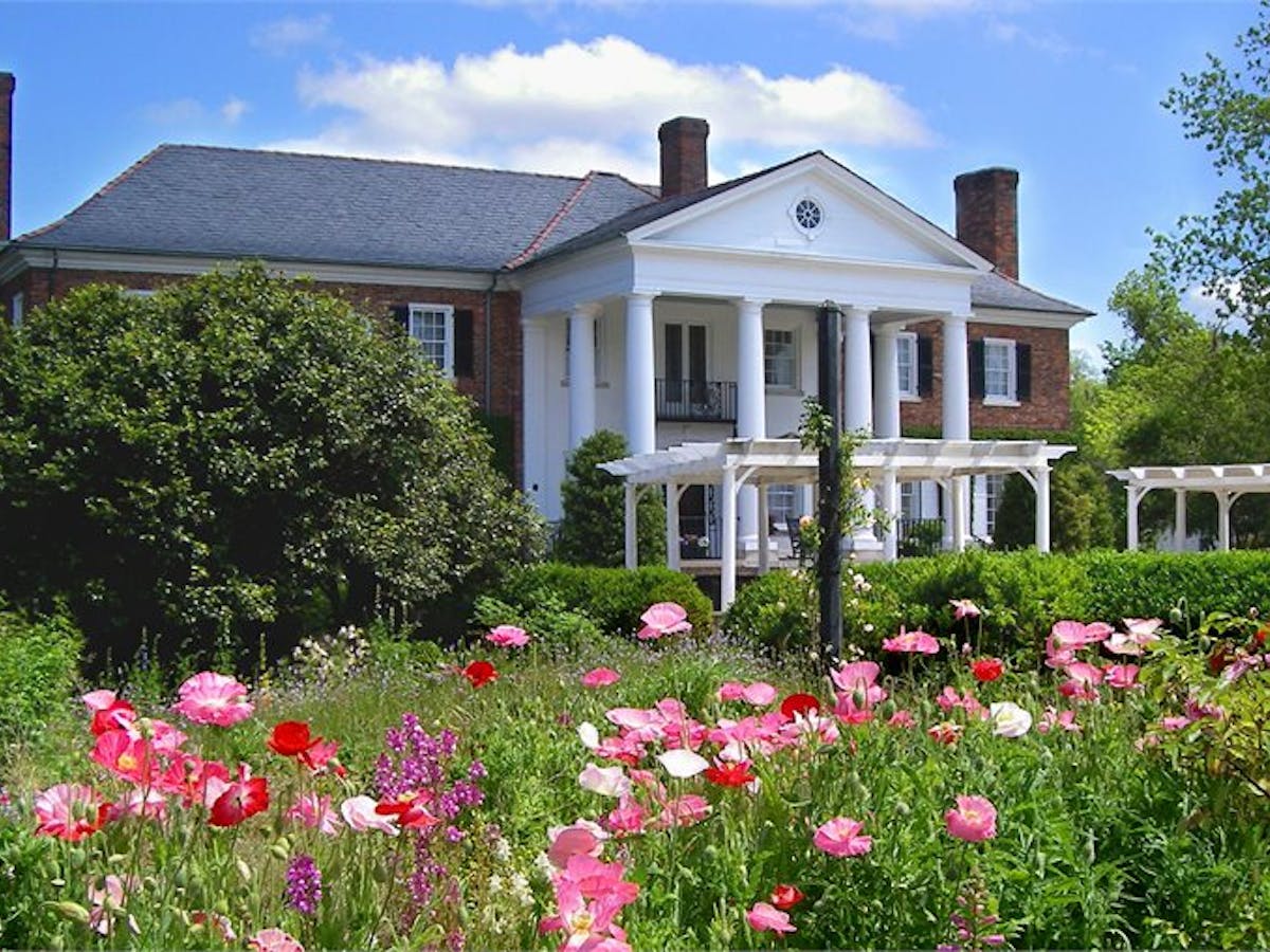 a colorful flower garden in front of a house