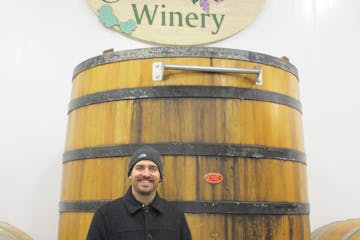 a man standing in front of a barrel
