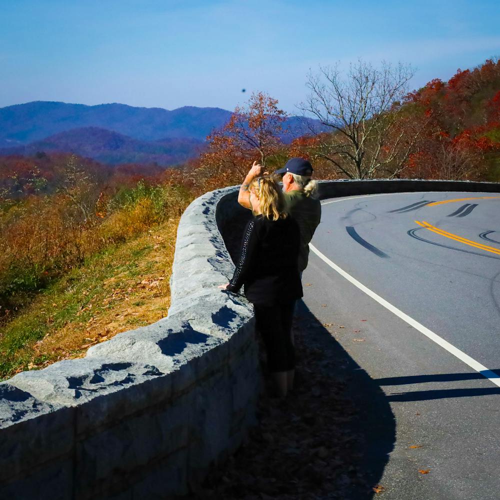 Couple taking scenic pictures on the Foothills Parkway in a guided Jeep tour with Smoky Mountains Jeep Tours.