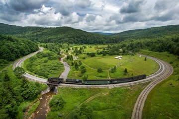 a train traveling through a lush green hillside